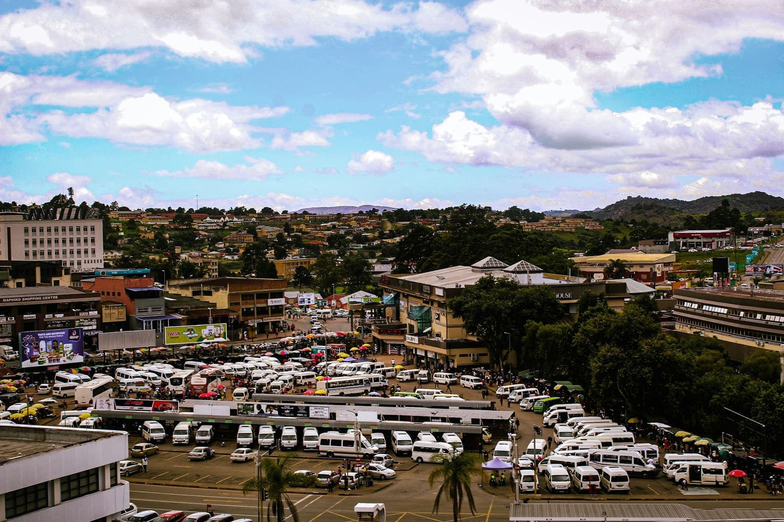 Rows of white minibus taxis parked on a city street in Eswatini